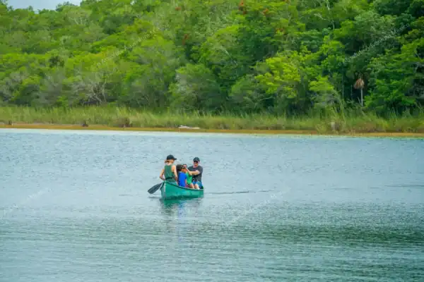 Family crossing  Punta Laguna in canoe