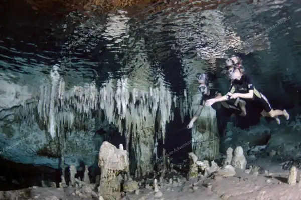 Snorkeler in cave  with stalactites Cenote Sac Actun