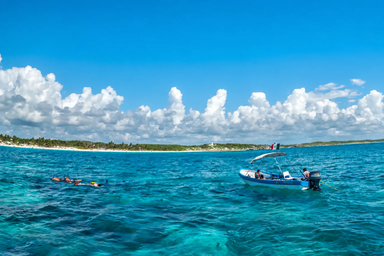 Snorkelers and a boat on the Caribbean Sea near Tulum