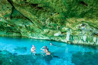 Tourist swimming in
  Dos Ojos cenote