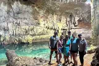 Group of friends
  posing inside Cenote Choo Ha