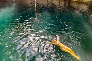 Lady relaxing at
  surface of X’Canche cenote