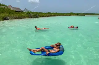 Girl floating in a
  boat on Kaan Luum Lagoon