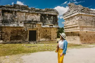 Lady pausing by
  Chichen Itza Nunnery facade