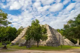 Platform structure
  surrounded by vegetation at Chichen Itza
