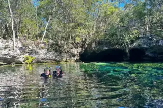 Two people swimming
  at Cenote Nicte-Ha