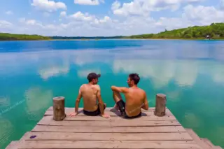 Two visitors
  sitting on lagoon pier